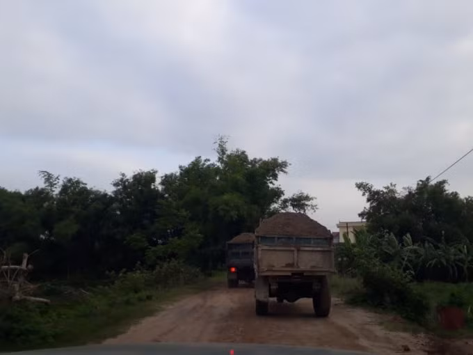 Các phương tiện nối đuôi nhau ra vào mua bán vật liệu xây dựng tại điểm tập kết của Công ty Cổ phần Vân Đức sau đó chạy lên tuyến đê của huyện Thường Tín, Hà Nội.