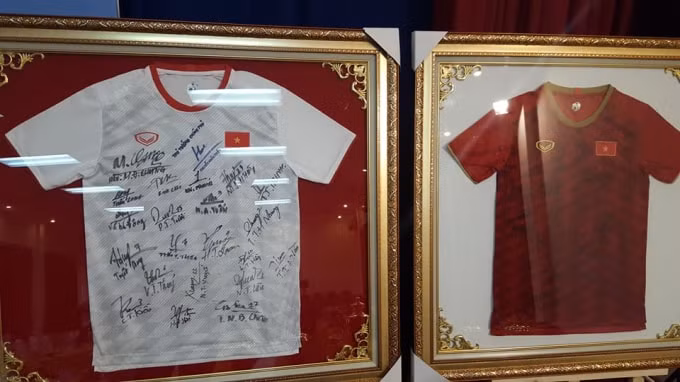 Hai chiếc áo có chữ ký của Thủ tướng Nguyễn Xuân Phúc, Ban Huấn luyện và tất cả các thành viên đội tuyển bóng đá nữ Việt Nam.