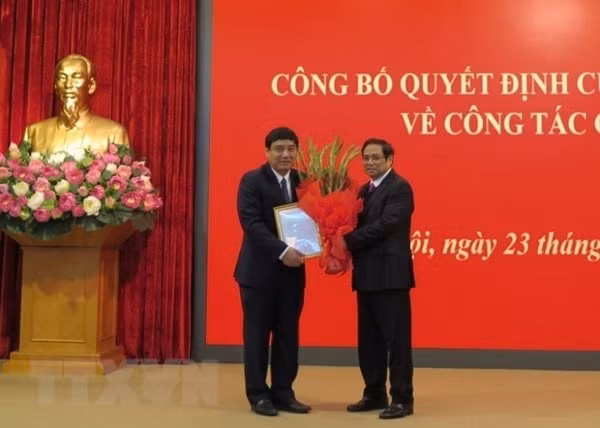 Ông Phạm Minh Chính, Ủy viên Bộ Chính trị, Bí thư Trung ương Đảng, Trưởng Ban Tổ chức Trung ương trao quyết định của Bộ Chính trị và tặng hoa chúc mừng ông Nguyễn Đắc Vinh. Ảnh: TTXVN