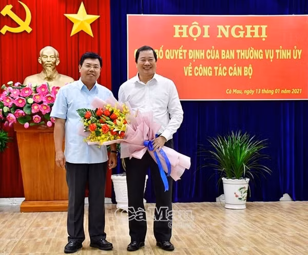 Bí thư Tỉnh uỷ Cà Mau Nguyễn Tiến Hải trao hoa, chụp ảnh lưu niệm với ông Thân Đức Hưởng (bên phải) tại buổi Lễ trao Quyết định nghỉ công tác, ngày13/1/2021. Ảnh: Báo Cà Mau