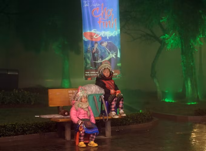 Những em bé ngồi bán hàng trong mưa lạnh.
