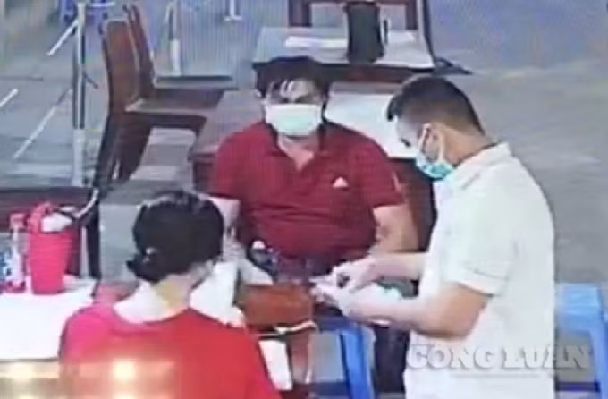 Nguyễn Văn Móm (mặc áo màu đỏ) lấy mẫu Text nhanh Covid-19 tại Bệnh viện ĐKTT An Giang - Hình chụp qua camera an ninh