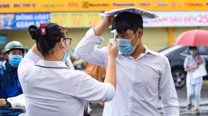 Thí sinh đội mưa đến điểm thi từ sáng sớm. Ảnh: Hoàng Đông