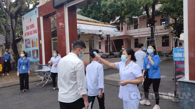 Nhân viên y tế kiểm tra thân nhiệt cho thí sinh tại điểm thi THPT Phan Đình Phùng (TP Hà Tĩnh)
