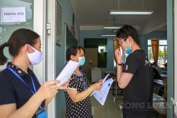 Khi đi vào làm thủ tục dự thi, thí sinh phải mang theo thẻ Căn cước công dân và Giấy báo dự thi tốt nghiệp THPT năm 2021. (Trên ảnh, giám thị đang yêu cầu thí sinh kéo khẩu trang xuống xem rõ đúng người trong ảnh CMT mới cho vào phòng thi).