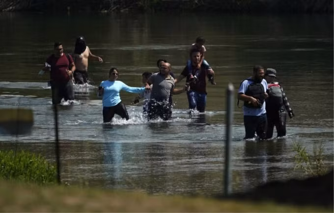 Một nhóm người di cư chủ yếu từ Venezuela lội qua sông Rio Grande để băng qua biên giới Hoa Kỳ-Mexico. (Nguồn: Eric Gay/AP Photo).