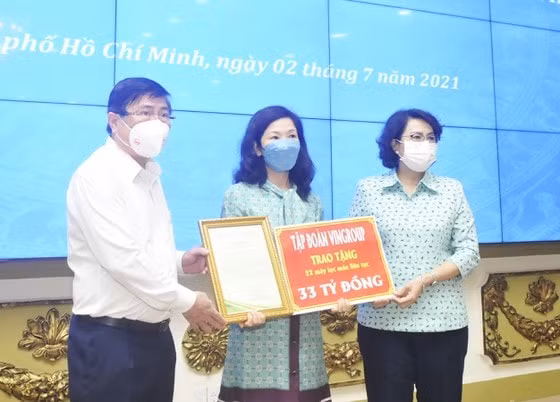Chủ tịch UBND TPHCM Nguyễn Thành Phong và Chủ tịch Ủy ban MTTQ Việt Nam TPHCM Tô Thị Bích Châu tiếp nhận bảng tượng trưng tặng trang thiết bị y tế của đại diện Tập đoàn Vingroup. Ảnh: CAO THĂNG