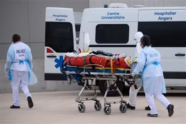 Nhân viên y tế chuyển bệnh nhân COVID-19 lên xe cứu thương tại Angers, Pháp ngày 15/3/2021. Ảnh: AFP