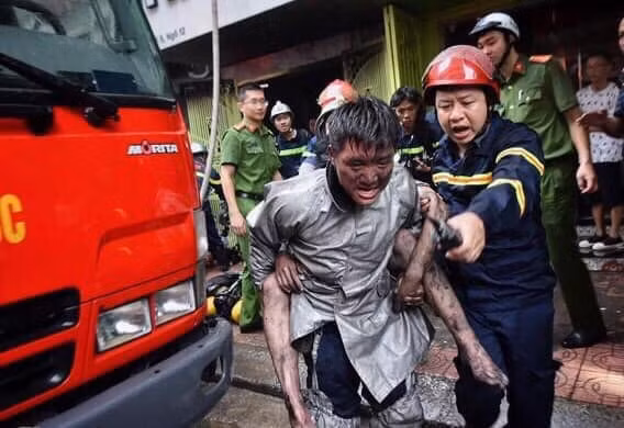 Trung úy Vũ Ngọc Hoàng cõng các nạn nhân thoát hiểm ở vụ cháy trên địa bàn quận Đống Đa. Ảnh TL