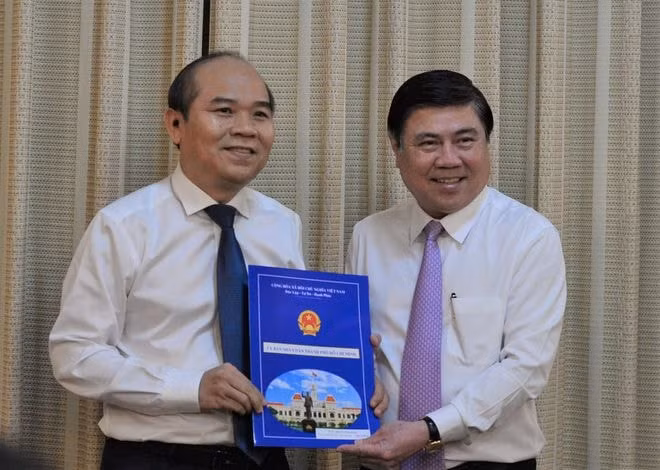 Chủ tịch UBND TP HCM Nguyễn Thành Phong trao quyết định bổ nhiệm ông Trần Văn Bảy làm Phó giám đốc Sở Tài nguyên Môi trường. Ảnh: TNO