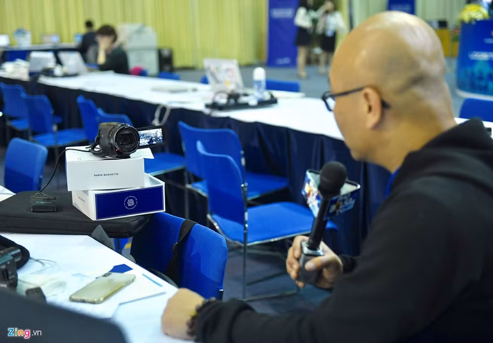 Anh Lan Vu, phóng viên của một trang tin cho cộng đồng người Việt tại Mỹ, tự đặt máy quay và tường thuật không khí tại trung tâm báo chí khi Tổng thống Trump đáp xuống Hà Nội. Anh cho biết cách làm việc thế này khá hiệu quả khi có ít người, nhưng anh lại không thể theo được hết các sự kiện. Vì vậy anh phải chọn lọc những sự kiện hợp lý để đưa tin. Ảnh: Quỳnh Trang.