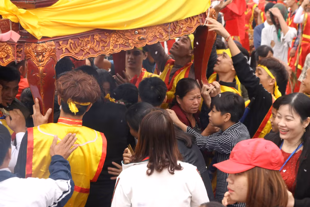 Người dân và du khách thập phương ồ ạt kéo nhau tìm cách chui qua kiệu để cầu may. Ảnh CTV