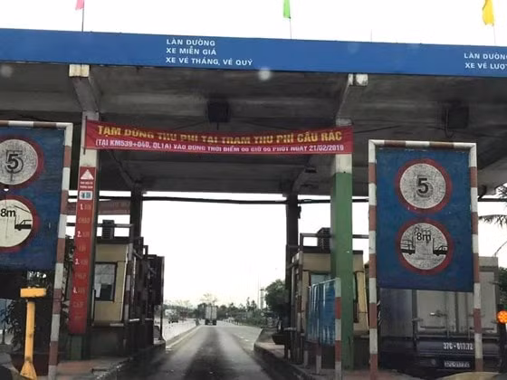 Băng rôn treo trên cổng trạm thu phí Cầu Rác thông báo tạm dừng thu phí. Ảnh PV