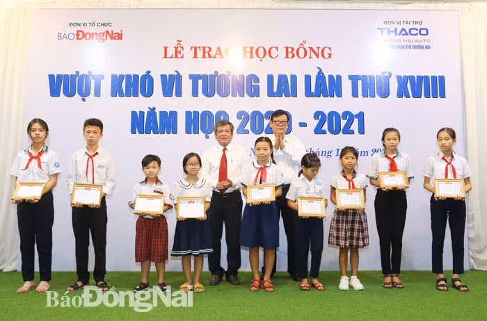 Tổng biên tập Báo Đồng Nai Nguyễn Tôn Hoàn và ông Nguyễn Một, Giám đốc truyền thông Công ty cổ phần Trường Hải trao học bổng cho các em học sinh. ảnh: Huy Anh