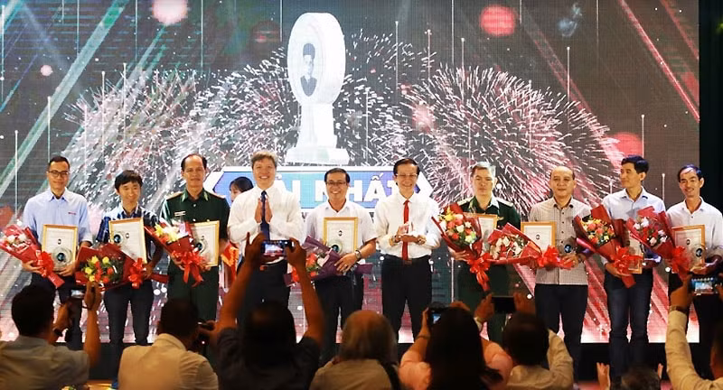 Phó Chủ tịch UBND tỉnh Hồ Quang Bửu và Phó Trưởng Ban Tuyên giáo Tỉnh ủy Nguyễn Hữu Sáng trao Giải nhất cho các tác giả. (ảnh Tấn Nguyên)