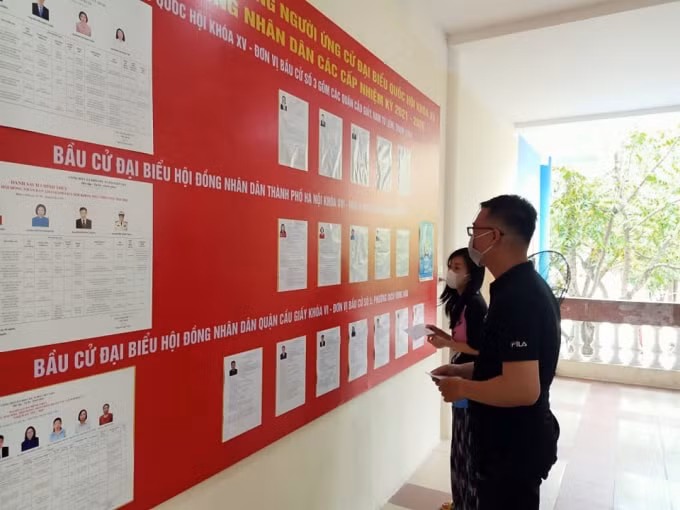 Sinh viên trường Đại học Ngoại ngữ, Đại học Quốc gia Hà Nội theo dõi danh sách các ứng cử viên. Ảnh: H.Đ