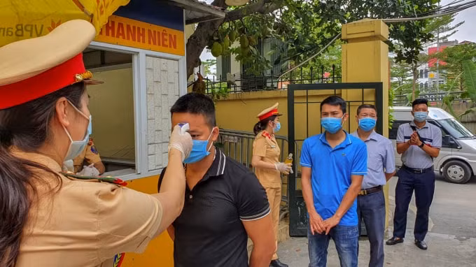 Các đội cảnh sát giao thông kiểm tra thân nhiệt của người dân đến cơ quan nhà nước làm thủ tục.