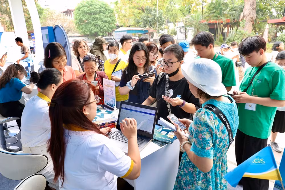 Ảnh 3 - Nhân viên Vietnam Airlines hướng dẫn khách tham quan thực hiện các thủ tục đăng ký dịch vụ tại hội chợ.