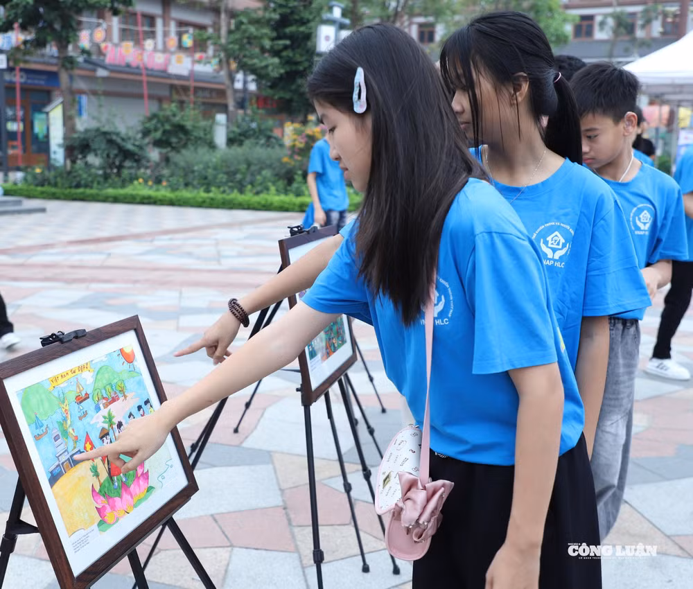 Những bức tranh do các em nhỏ khuyết tật vẽ thu hút người dân và người khuyết tật.