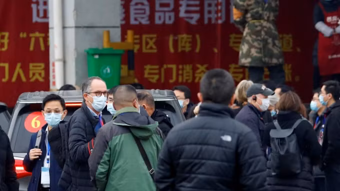 Các chuyên gia của WHO bên ngoài chợ hải sản Huanan, Vũ Hán. Ảnh: Reuters