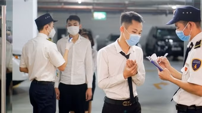 Tiến hành kiểm tra thân nhiệt khách hàng.