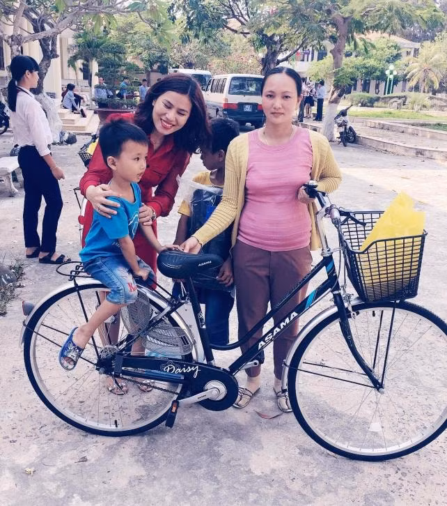 Nhà báo Thanh Thảo (áo đỏ) trong chuyến vận động các doanh nghiệp trao tặng quà cho con em các gia đình công nhân.