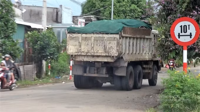 Chở đá vượt thùng xe, phủ bạt vải tạm bợ làm đá rơi xuống đường, gây nguy hiểm cho người tham gia giao thông bằng xe 2 bánh.