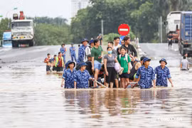Cảnh sát biển ngâm mình dìu dân vượt qua điểm ngập sâu gần 1m ở Hà Nội