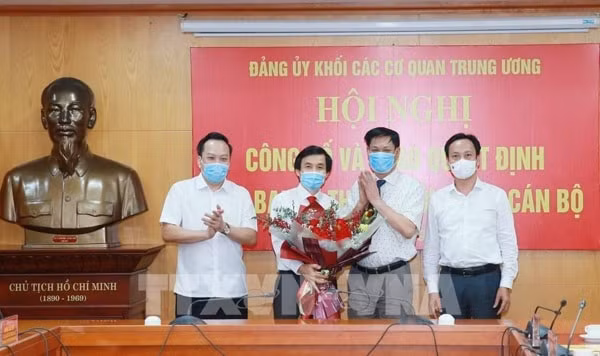 Ông Huỳnh Tấn Việt tặng hoa, chúc mừng ông Nguyễn Quang Trường. Ảnh: TTXVN