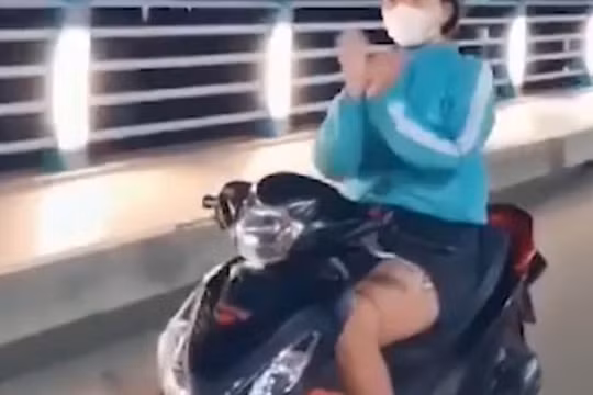 Chạy xe máy thả tay 'múa quạt', cô gái bị phạt 7,4 triệu đồng