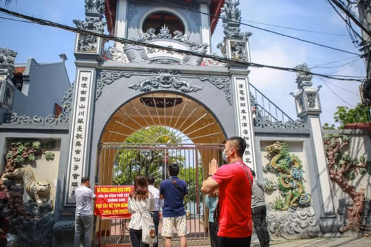 Hà Nội: Đền chùa đóng cửa, người dân hành lễ, thắp hương, vái vọng trước cổng chùa