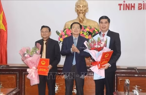 Ông Hồ Quốc Dũng, Bí thư Tỉnh ủy, Chủ tịch HĐND tỉnh Bình Định trao quyết định và tặng hoa chúc mừng các ông Lâm Hải Giang (phải) và Nguyễn Tự Công Hoàng (trái). Ảnh: TTXVN