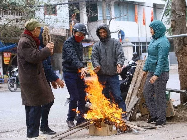Người dân đốt củi để sưởi ấm tránh rét. Ảnh: TTXVN