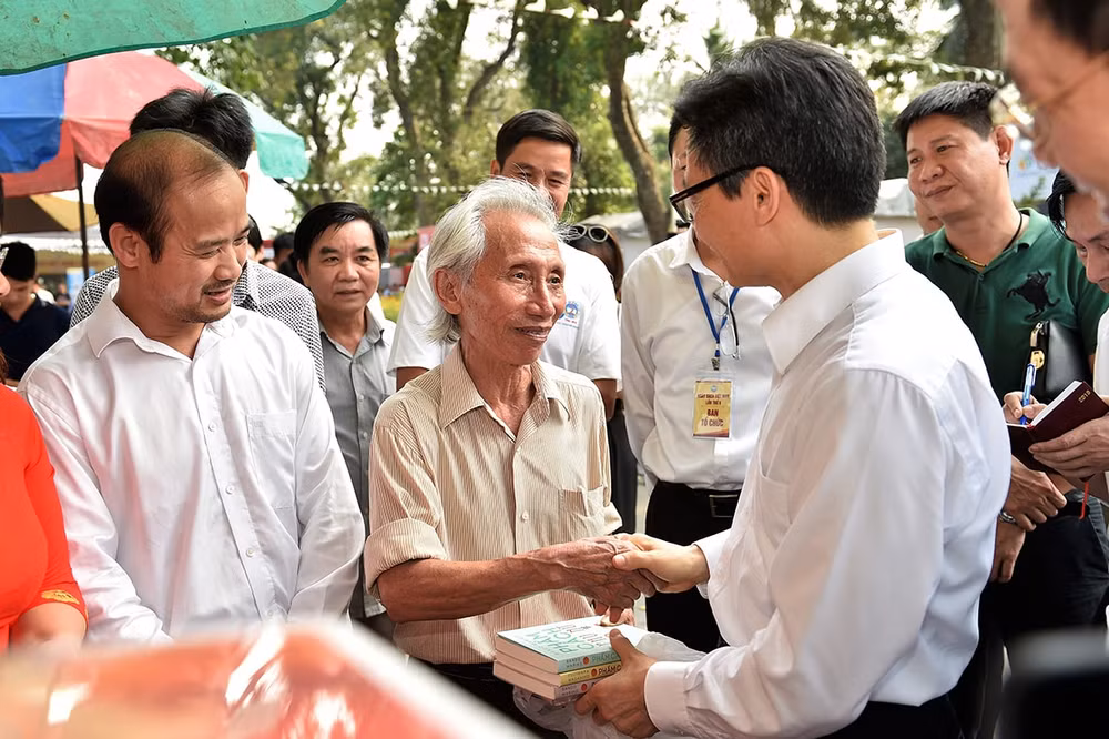 Phó Thủ tướng Vũ Đức Đam tặng bộ sách cho bác Nguyễn Hải Đăng. Ảnh: VGP
