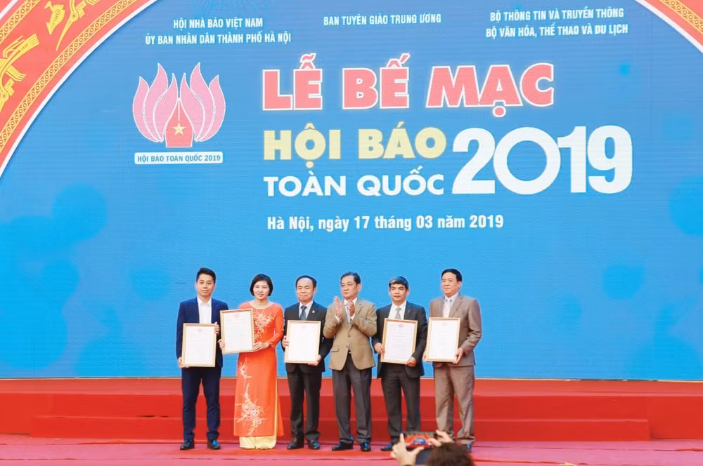 Ông Nguyễn Bé - Phó Chủ tịch Hội Nhà báo Việt Nam trao giải cho các đơn vị, cá nhân đoạt giải Công trình nghiên cứu khoa học và nghiệp vụ báo chí tại Hội báo Toàn quốc 2019.