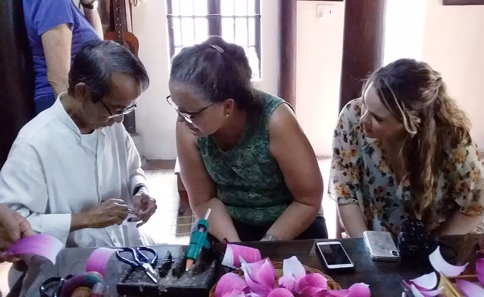 Du khách nước ngoài thích thú với nghề làm hoa giấy.