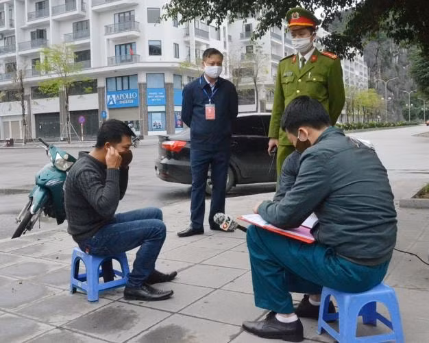Lực lượng chức năng phường Hồng Hải, TP Hạ Long, lập biên bản xử phạt vi phạm về quy định phòng chống dịch Covid-19. Ảnh: Nguyễn Thanh