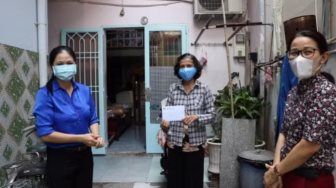 Người bán vé số lưu động cư ngụ tại quận Bình Thạnh nhận hỗ trợ từ đại diện MTTQ địa phương