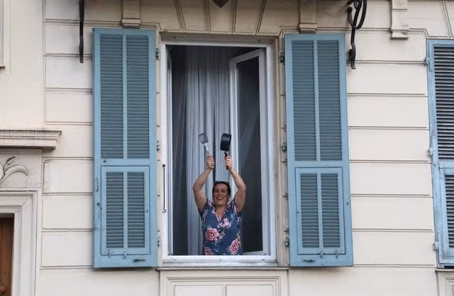Người dân Paris gõ nồi bên cửa sổ nhằm cảm ơn những y bác sĩ đang căng mình trong mùa dịch. Ảnh:Reuters