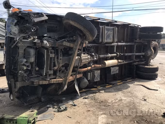 Cú tông mạnh khiến xe tải chở gỗ lật ngang trên đường.