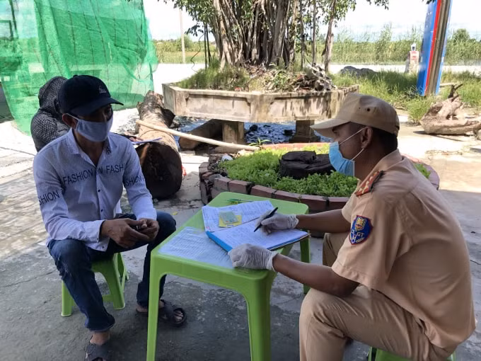 Lực lượng chức năng làm việc với tài xế xe tải. (Ảnh: Hoàng Giang)