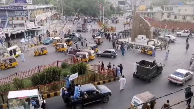 Các chiến binh Taliban vẫy cờ Taliban trên một chiếc xe bán tải chạy qua một con phố đông đúc tại khu vực Quảng trường Pashtunistan ở Jalalabad - Ảnh: Reuters