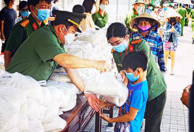 Lực lượng công an nhân dân tặng gạo cho người gặp khó khăn do dịch COVID-19.