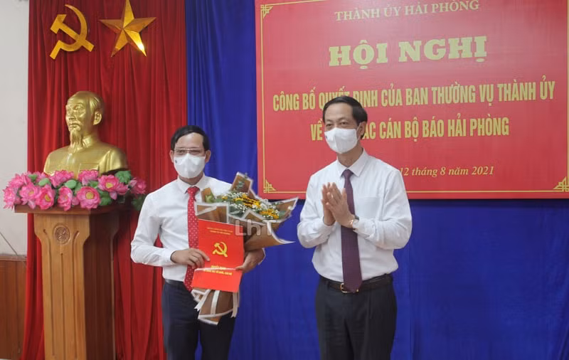 Đồng chí Đỗ Mạnh Hiến, Phó Bí thư Thường trực Thành ủy Hải Phòng trao Quyết định và tặng hoa cho đồng chí Nguyễn Hồng Dương. Ảnh: Hoàng Tùng