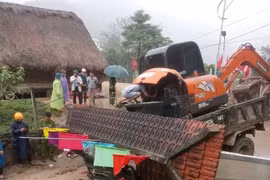 Xe tải chở xe múc tông sập cổng chào, 2 người tử vong