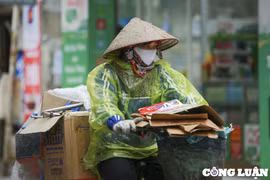 Người dân Hà Nội mặc kín áo ấm, áo mưa ra đường trong thời tiết giá rét