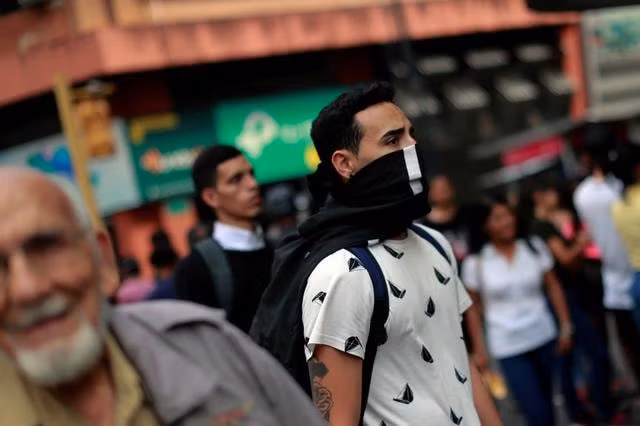 Một người đàn ông bịt mặt tại Caracas, Venezuela. Ảnh: Reuters