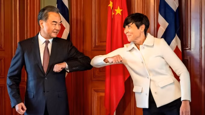 Bộ trưởng Ngoại giao Trung Quốc Vương Nghị (trái) và Bộ trưởng Ngoại giao Na Uy Ine Eriksen Soreide chào nhau bằng một cú thúc cùi chỏ ở Oslo vào ngày 27 tháng 8 - Ảnh: NTB Scanpix via Reuters