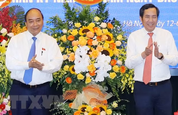 Thủ tướng Nguyễn Xuân Phúc tặng hoa chúc mừng ông Thuận Hữu, Ủy viên Trung ương Đảng, Tổng Biên tập Báo Nhân Dân, Phó Trưởng Ban Tuyên giáo Trung ương, Chủ tịch Hội Nhà báo Việt Nam. (Ảnh: Thống Nhất/TTXVN)