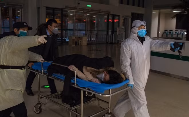 Các bác sĩ tại Vũ Hán đưa một phụ nữ mang thai nhiễm virus corona vào khu vực cách ly. Ảnh: Xinhua